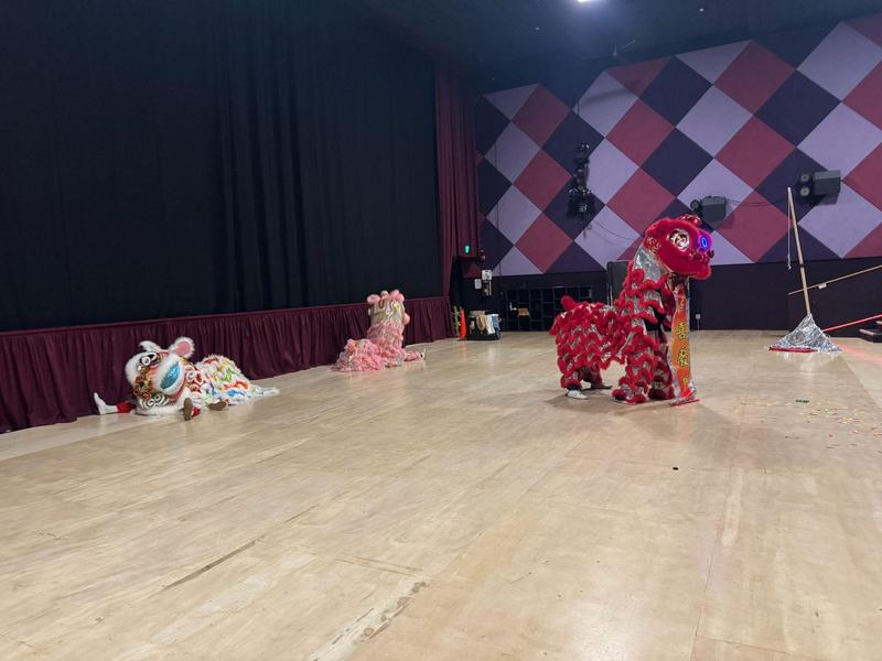 Lion dancers rest on stage between performances